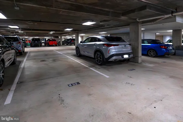 an outdoor space with lots of cars parked on the road