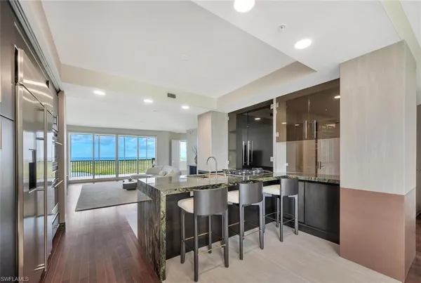 a kitchen with stainless steel appliances kitchen island granite countertop a refrigerator and a stove top oven