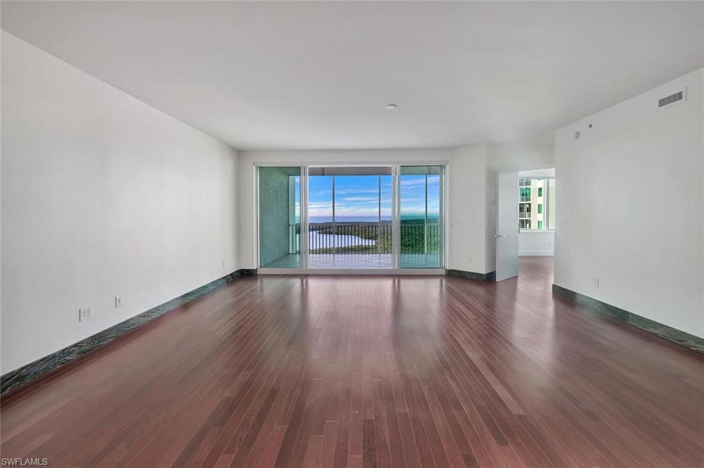 275 Indies Way, Unit 1605 Naples, FL 34110 - Photo 16 of 50 wooden floor in an empty room with a window
