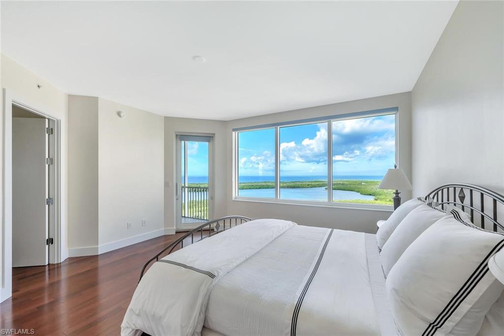 275 Indies Way, Unit 1605 Naples, FL 34110 - Photo 27 of 50 a bed sitting in a bedroom next to a window