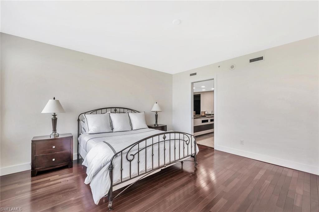 275 Indies Way, Unit 1605 Naples, FL 34110 - Photo 28 of 50 a bedroom with a bed and a night stand