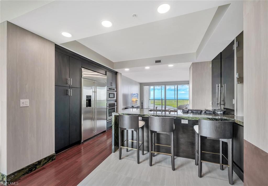 275 Indies Way, Unit 1605 Naples, FL 34110 - Photo 10 of 50 a large kitchen with a table and chairs
