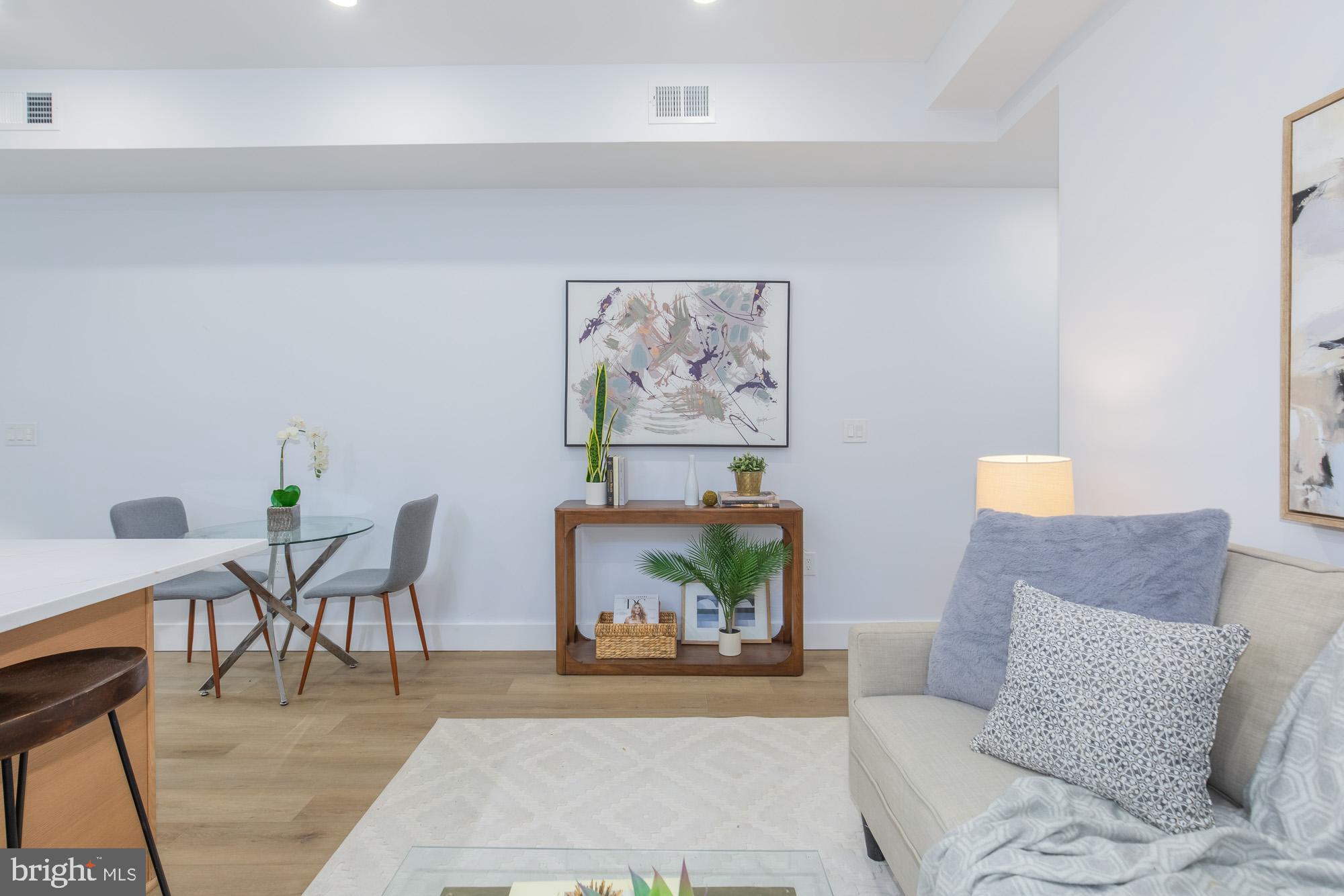1012 17th Place Northeast, Unit 1 Washington, DC 20002 - Photo 3 of 18 a living room with furniture and a painting on the wall