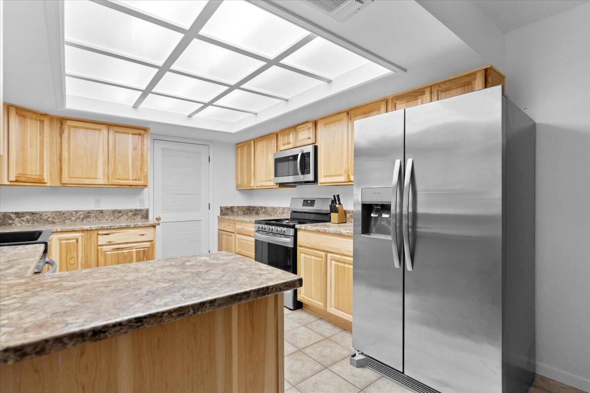 5210 Balls Ferry Road Anderson, CA 96007 - Photo 10 of 68 a kitchen with stainless steel appliances granite countertop a refrigerator a sink dishwasher a stove top oven a kitchen island and chairs with wooden floor