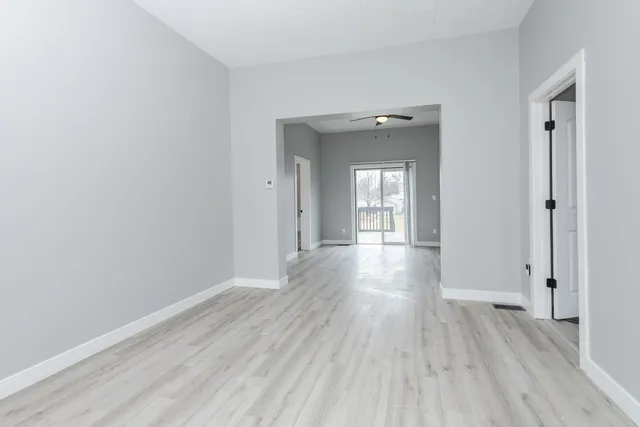 a view of a hallway with wooden floor and closet