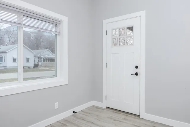 a view of a small space with wooden floor and a window