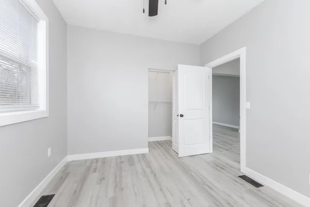 an empty room with wooden floor and windows