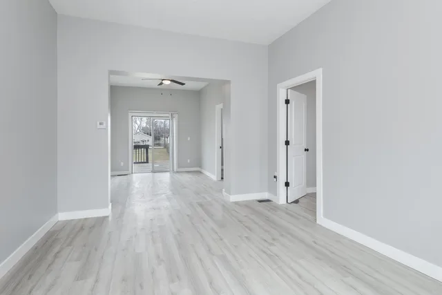 an empty room with wooden floor and mirror