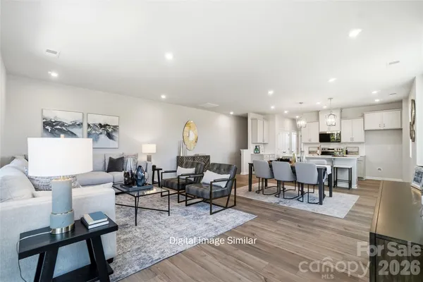 a living room with lots of furniture and kitchen view