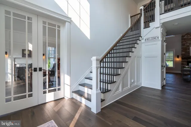 a living room with furniture a flat screen tv and a floor to ceiling window