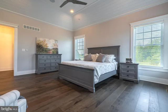 a bedroom with a bed and dresser with mirror