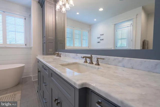 a kitchen with stainless steel appliances granite countertop a table chairs and a refrigerator