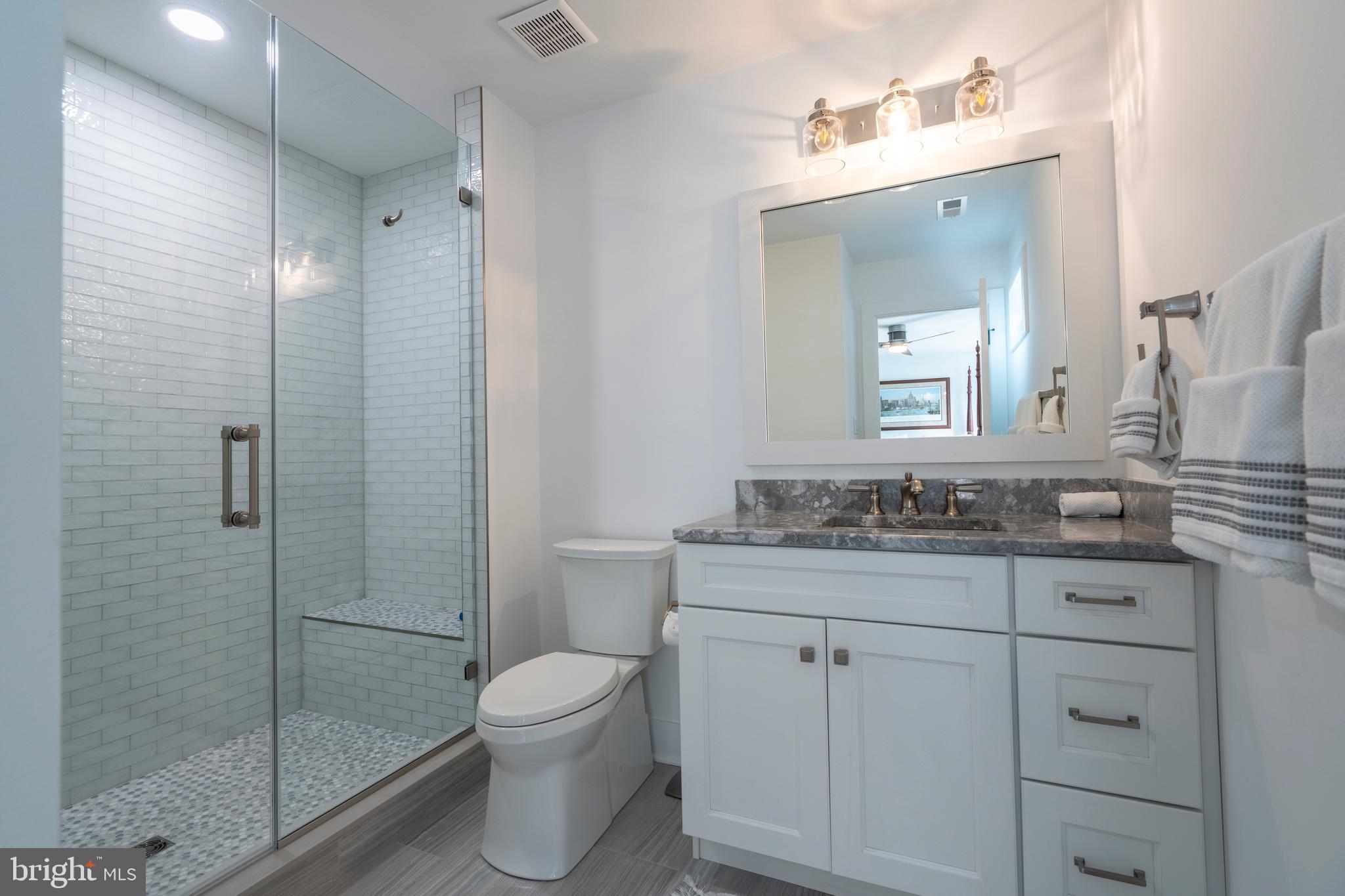 1161 Upper Stump Road Chalfont, PA 18914 - Photo 55 of 102 a bathroom with a granite countertop toilet a sink a mirror and shower
