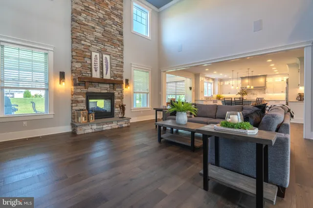 a kitchen with stainless steel appliances kitchen island granite countertop a wooden floor and a refrigerator