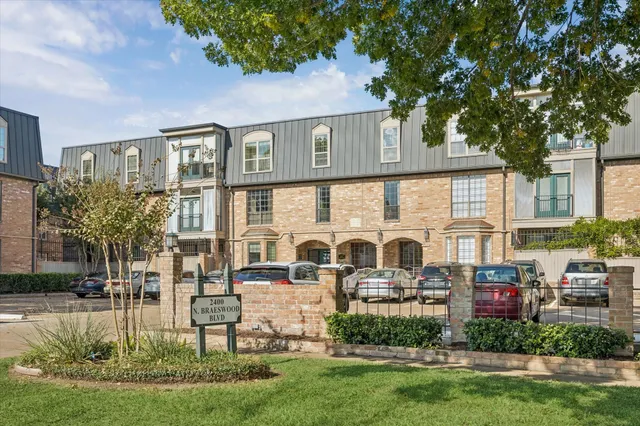 a front view of a house with a garden and plants