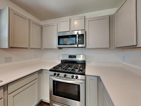 a kitchen with stainless steel appliances granite countertop a refrigerator and a stove