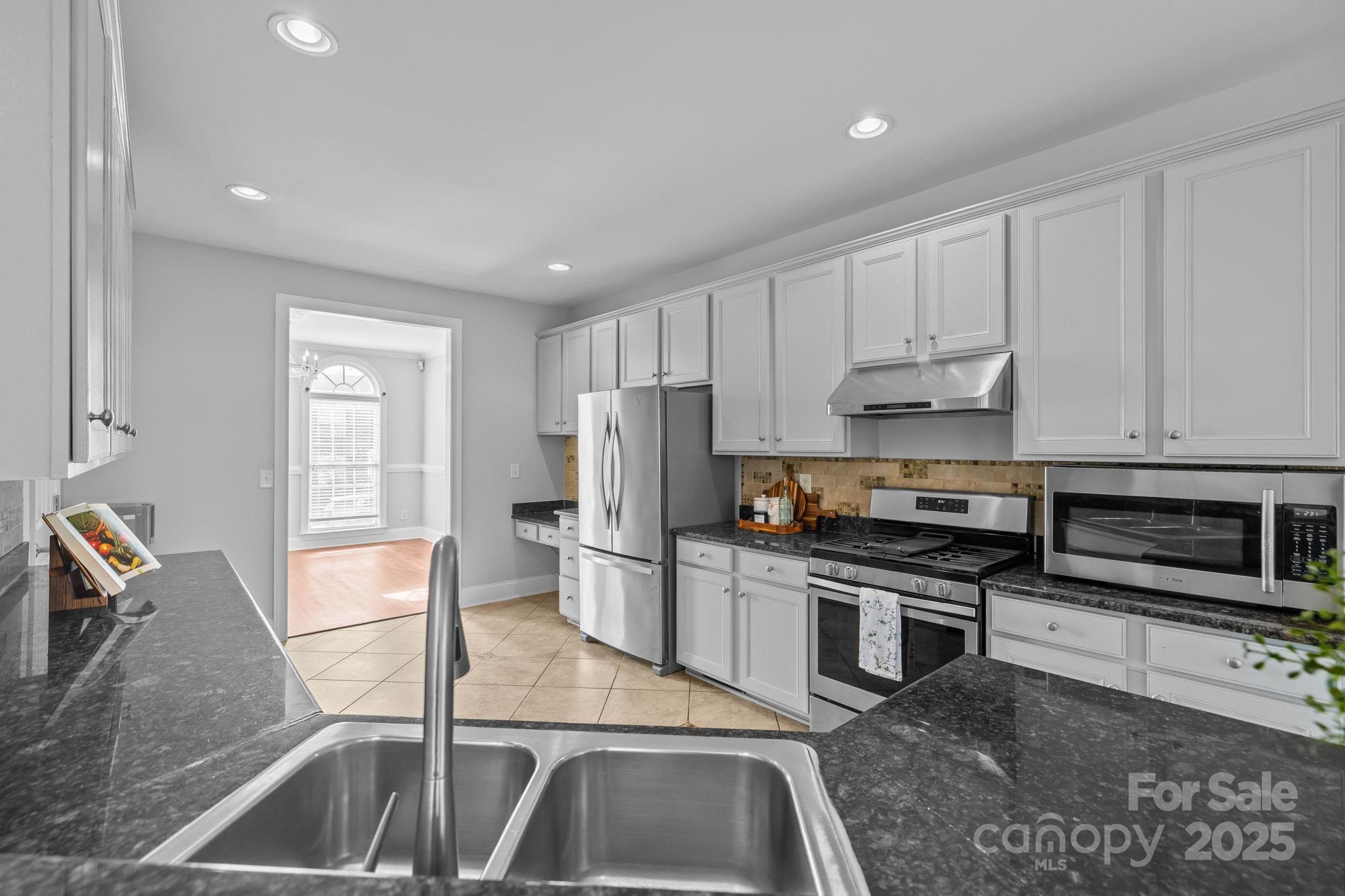 4424 Sunset Rose Drive Fort Mill, SC 29708 - Photo 12 of 47 a kitchen with stainless steel appliances granite countertop a sink stove and refrigerator