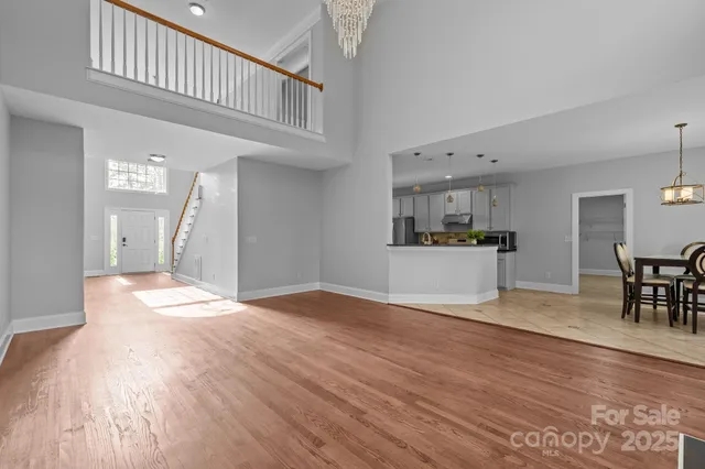 a view of empty room with wooden floor and furniture