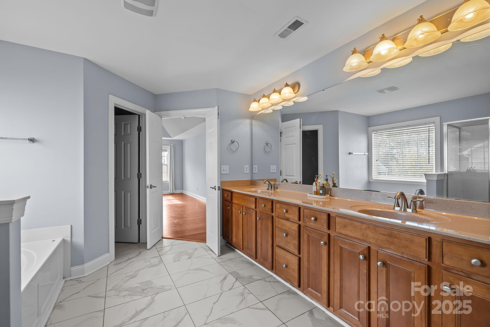 4424 Sunset Rose Drive Fort Mill, SC 29708 - Photo 25 of 47 a spacious bathroom with a double vanity sink and a mirror