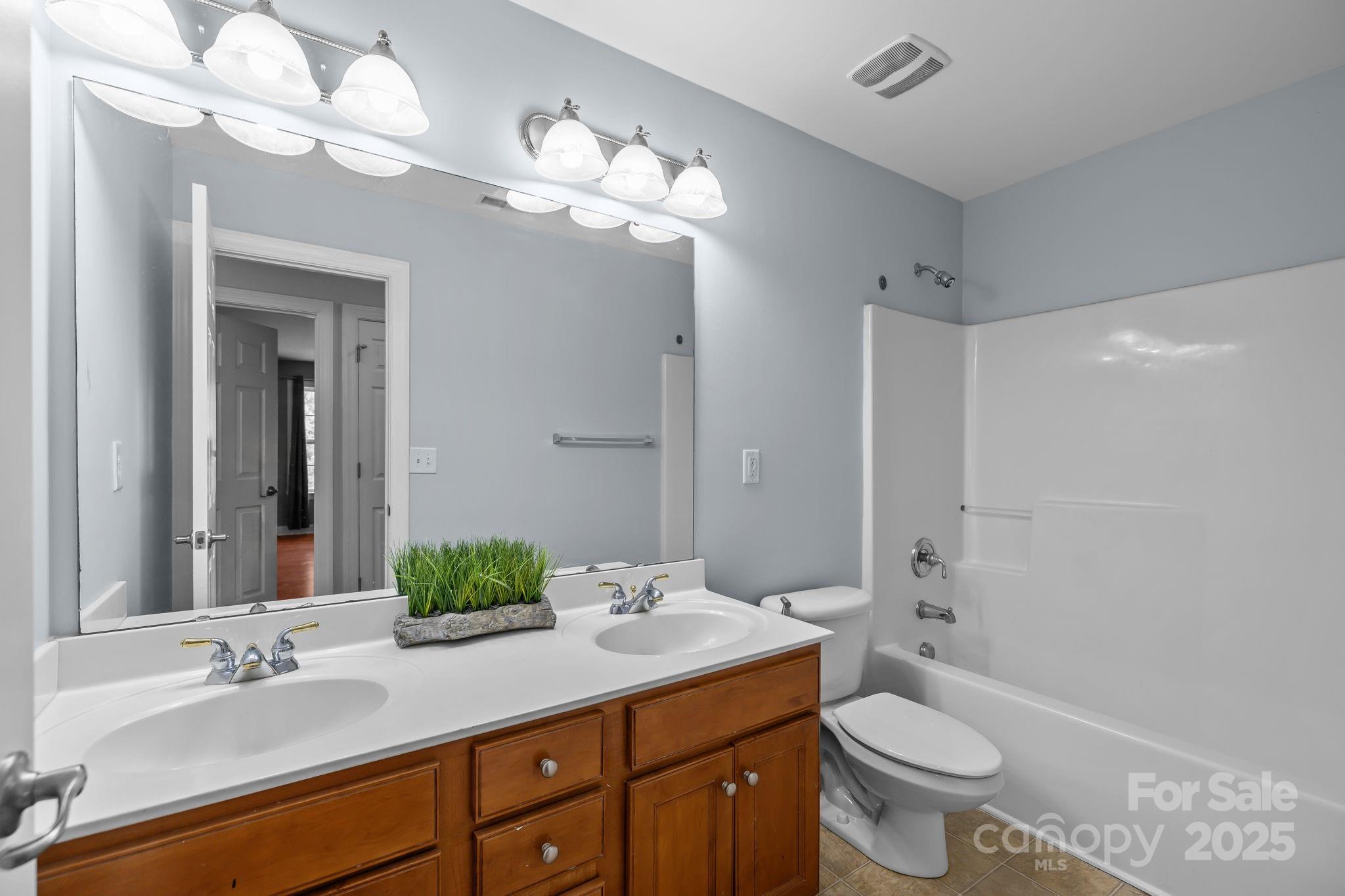 4424 Sunset Rose Drive Fort Mill, SC 29708 - Photo 29 of 47 a bathroom with a sink a toilet and a large mirror