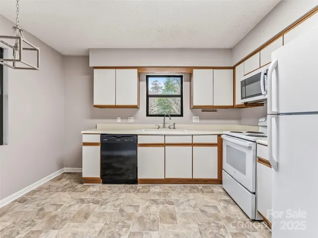 a kitchen with granite countertop a stove sink and cabinets