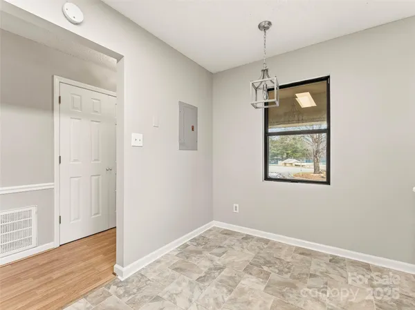 an empty room with windows and cabinet