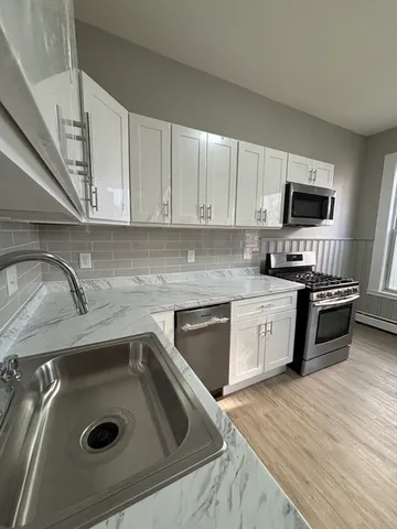 a kitchen with a sink a stove and cabinets