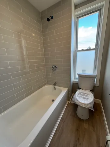 a bathroom with a bathtub a toilet a sink and a shower