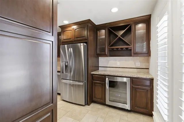 a metallic refrigerator freezer sitting in a kitchen