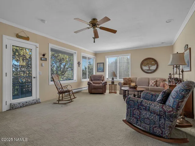 a living room with furniture a clock chandelier and a window
