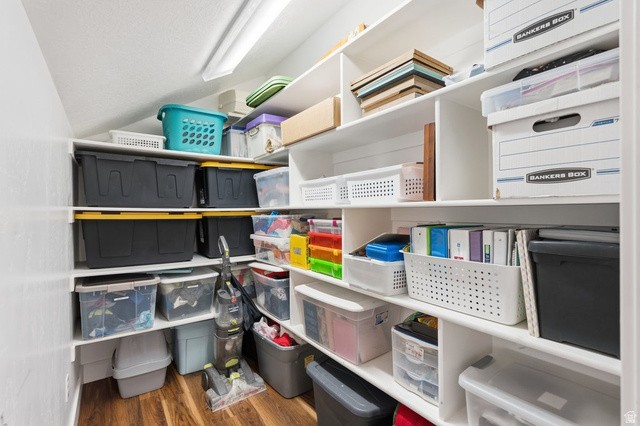 672 Perry Hollow Drive Mapleton, UT 84664 - Photo 72 of 106 Expansive storage closet featuring multiple built-in white shelving units, wood-finish flooring, and overhead lighting
