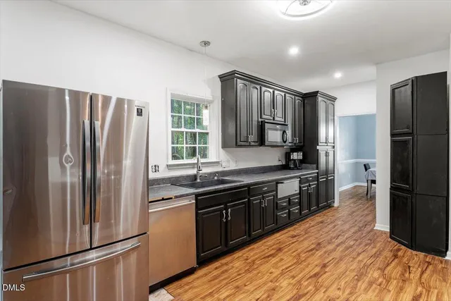 a kitchen with stainless steel appliances granite countertop a refrigerator and a sink