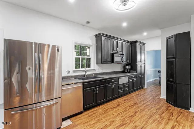 a kitchen with granite countertop a sink stove and refrigerator