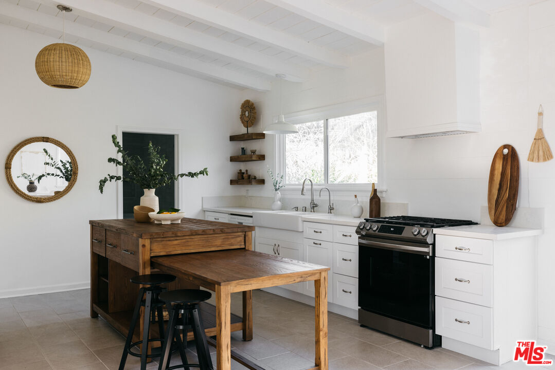 5907 Meridian Street Los Angeles, CA 90042 - Photo 11 of 27 a kitchen with stainless steel appliances granite countertop a stove a sink and a refrigerator