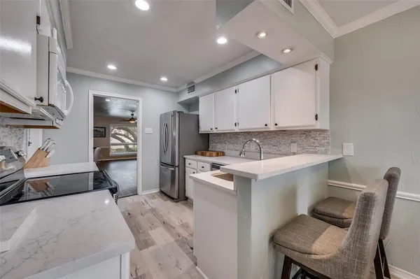 a kitchen with a sink cabinets and wooden floor