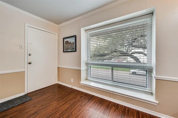 a view of a small space with wooden floor and a window