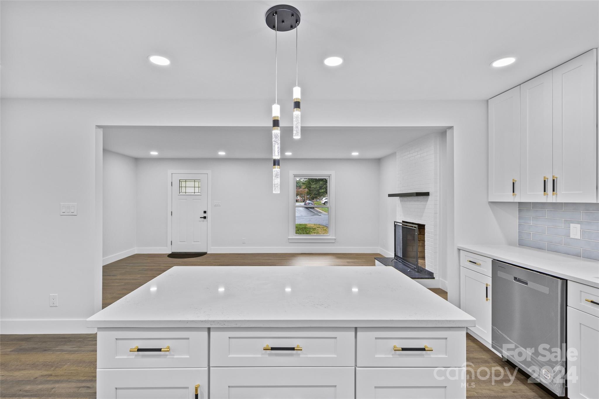 5745 Ruth Drive Charlotte, NC 28215 - Photo 15 of 42 a view of a kitchen with a sink dishwasher and a fireplace with wooden floor
