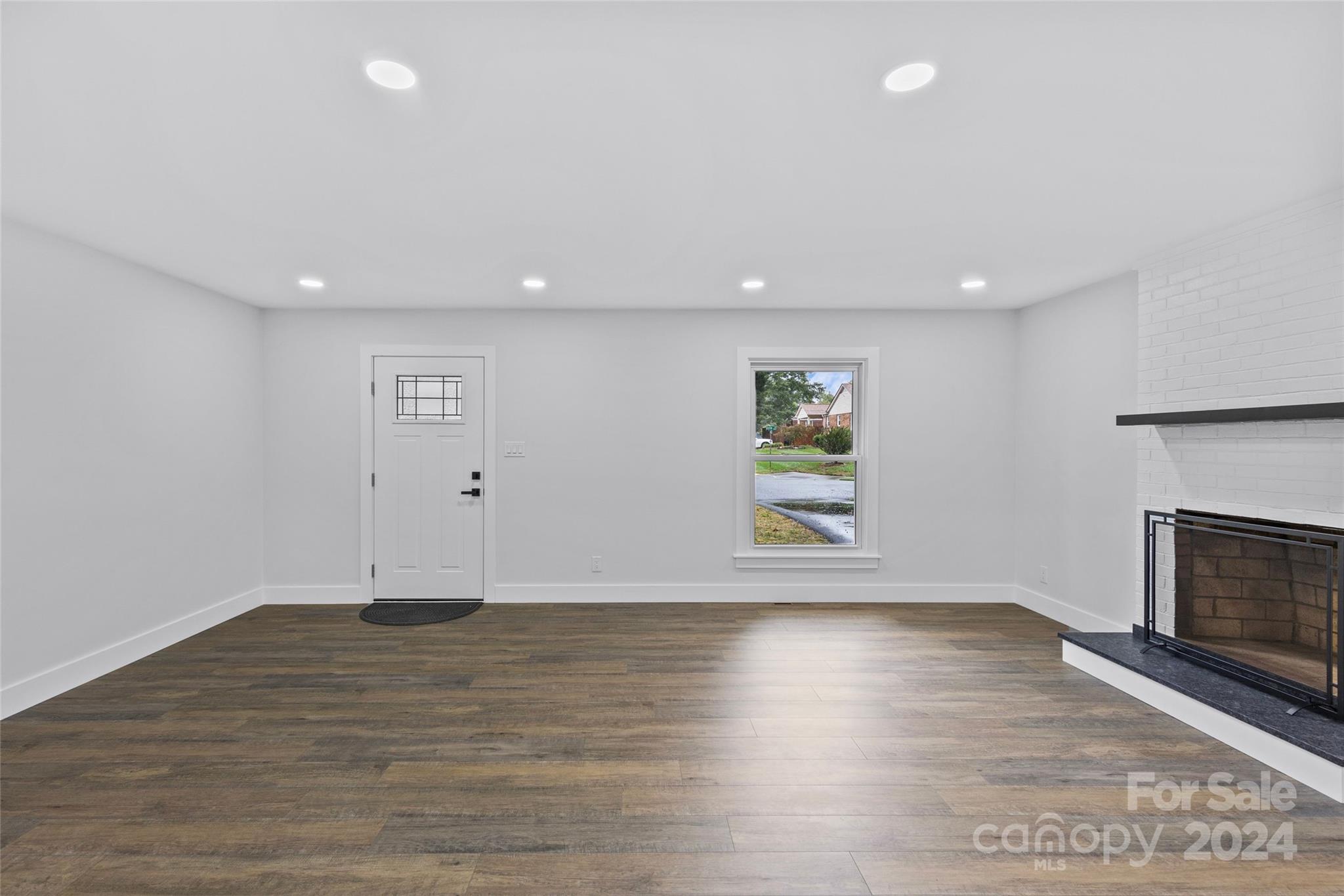 5745 Ruth Drive Charlotte, NC 28215 - Photo 4 of 42 an empty room with wooden floor and fireplace