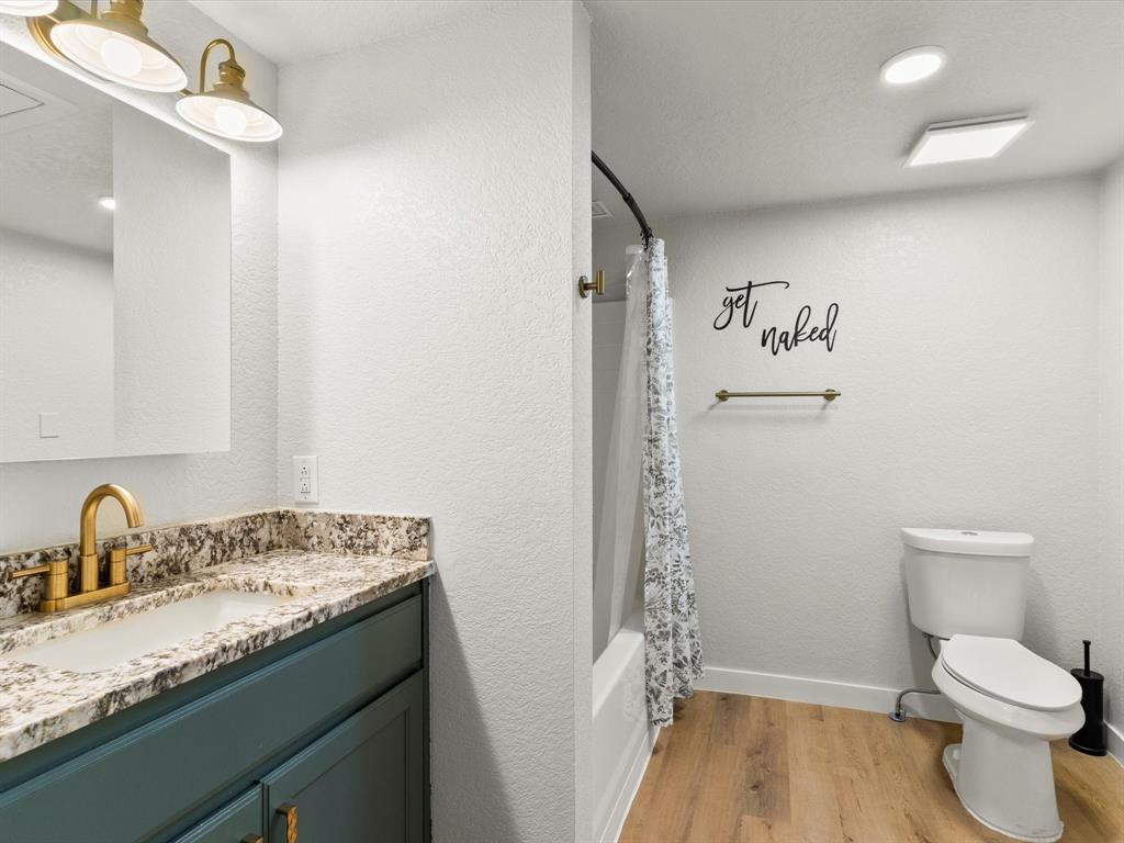 901 South Lane Street Decatur, TX 76234 - Photo 12 of 23 Full bathroom with vanity, toilet, hardwood / wood-style floors, and shower / bath combo