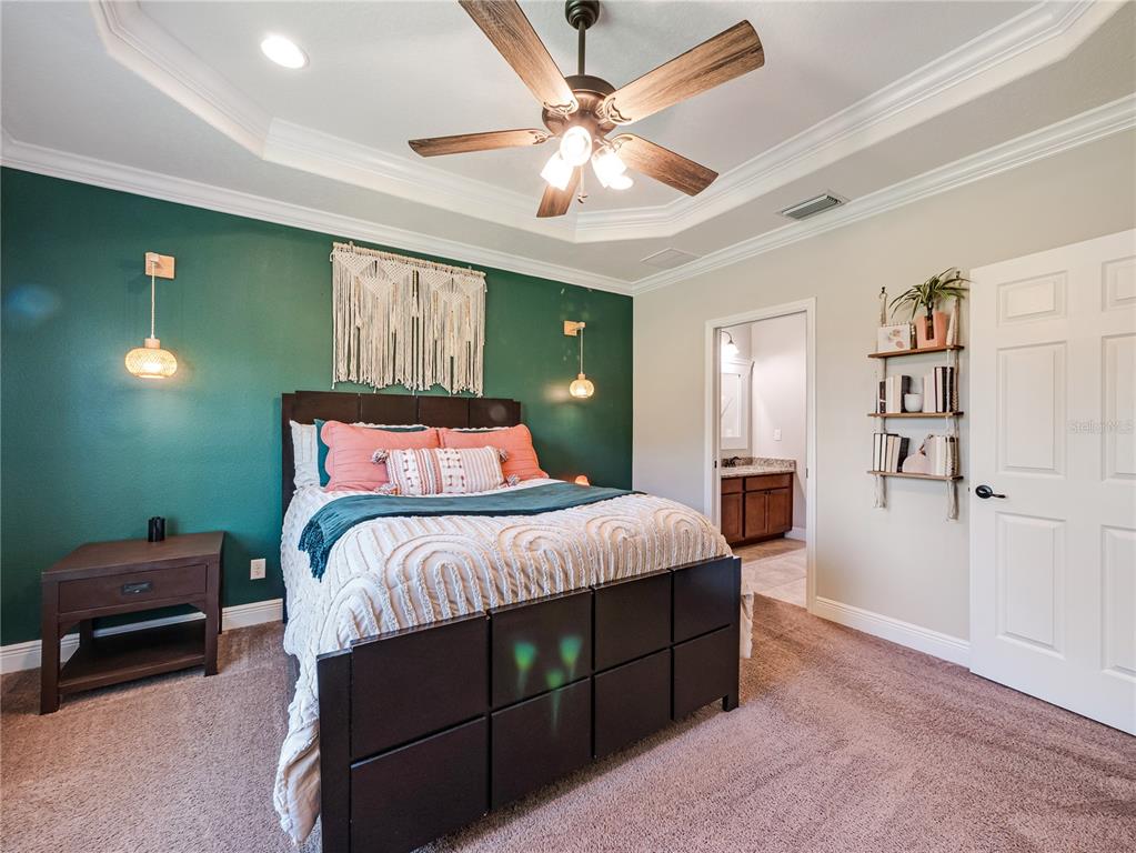 8416 Magnificent Road Groveland, FL 34736 - Photo 13 of 28 a bedroom with a bed and a chandelier
