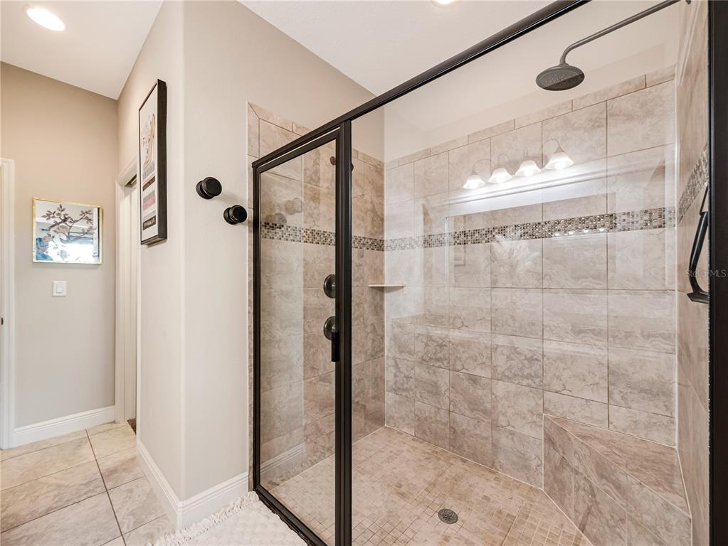 8416 Magnificent Road Groveland, FL 34736 - Photo 16 of 28 a bathroom with a glass shower door