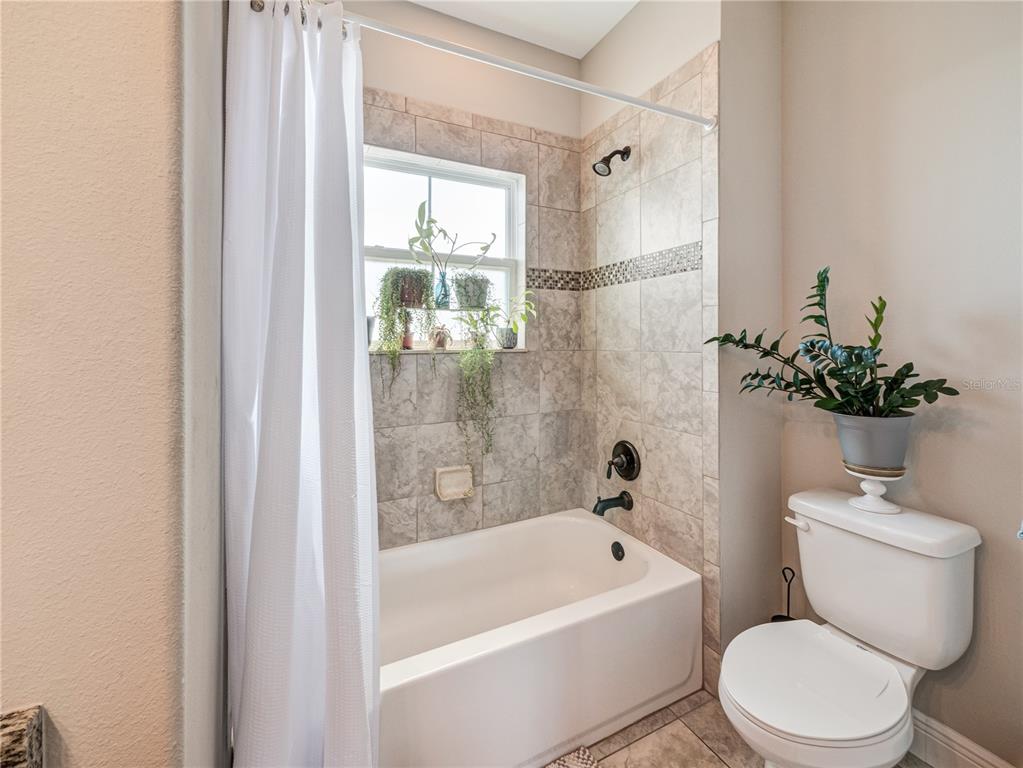 8416 Magnificent Road Groveland, FL 34736 - Photo 24 of 28 a white toilet sitting next to a bath tub