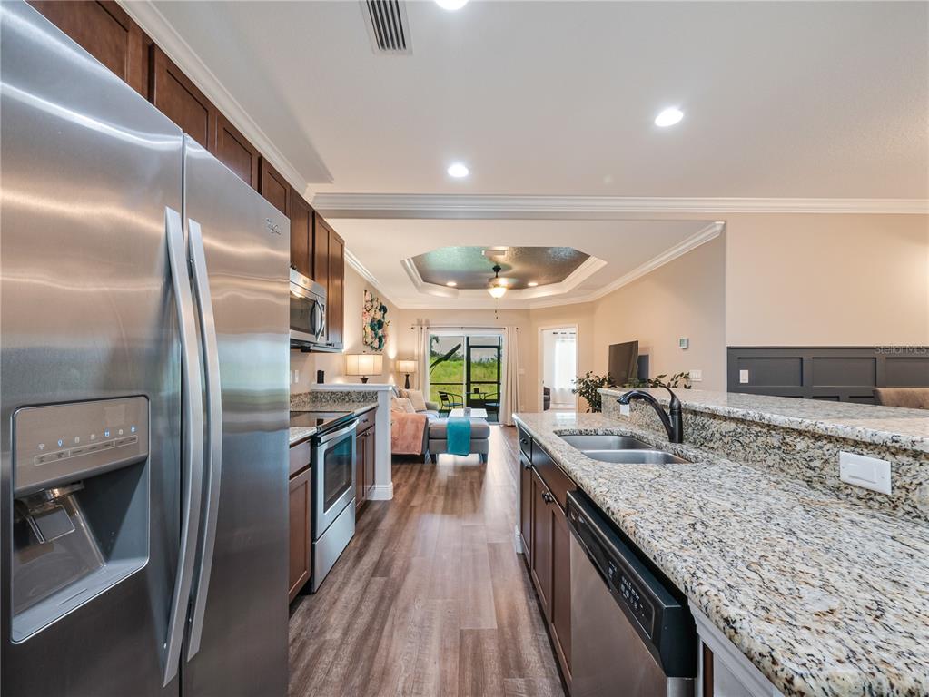 8416 Magnificent Road Groveland, FL 34736 - Photo 5 of 28 a kitchen with stainless steel appliances granite countertop a sink stove and refrigerator