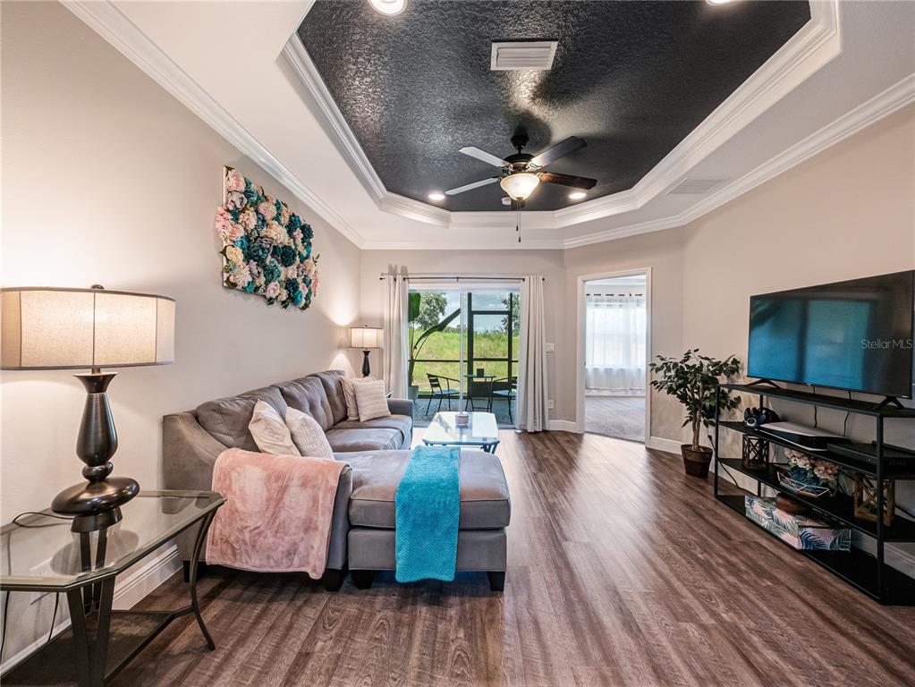 8416 Magnificent Road Groveland, FL 34736 - Photo 9 of 28 a living room with furniture and a flat screen tv