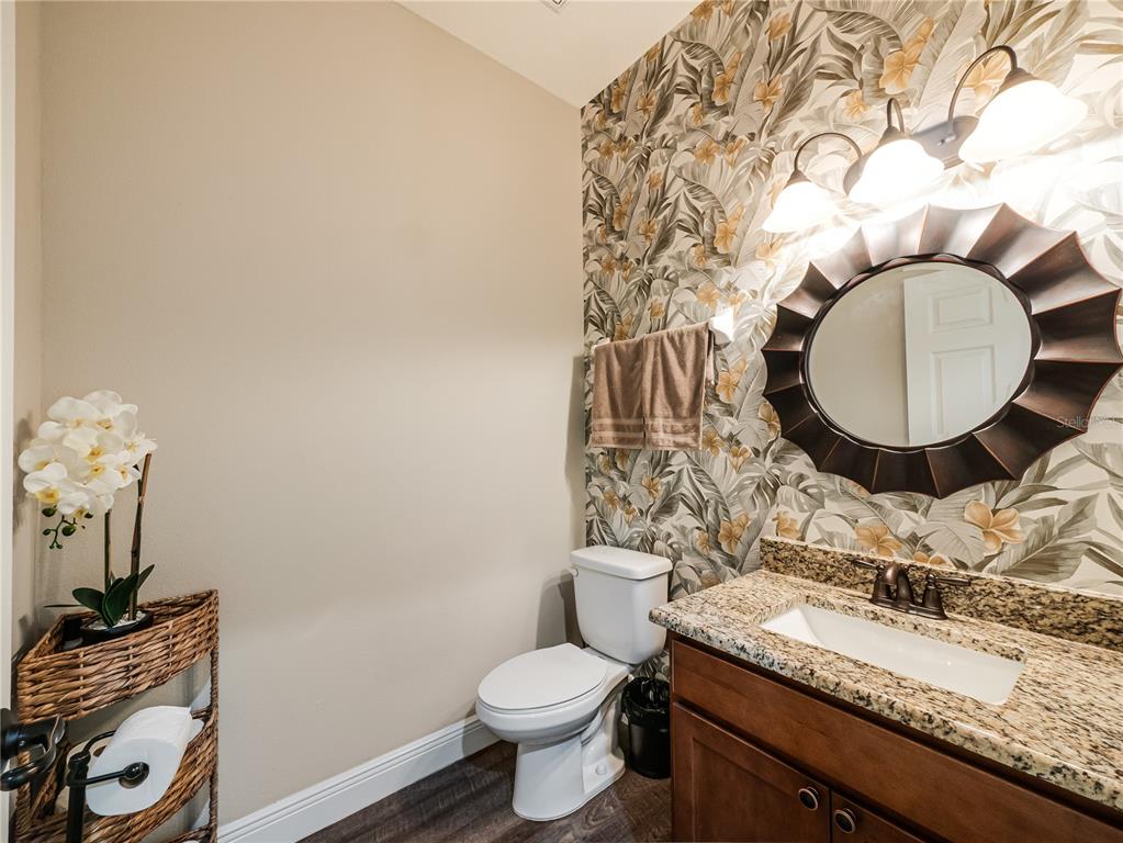 8416 Magnificent Road Groveland, FL 34736 - Photo 10 of 28 a bathroom with a granite countertop toilet sink and mirror