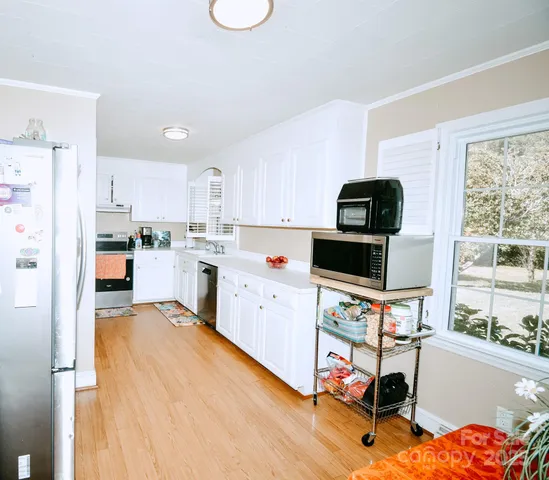 a kitchen with a sink a stove a refrigerator cabinets and a window