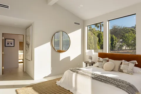 a bedroom with bed and a large window