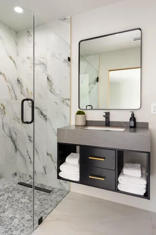a bathroom with a double vanity sink a mirror and shower