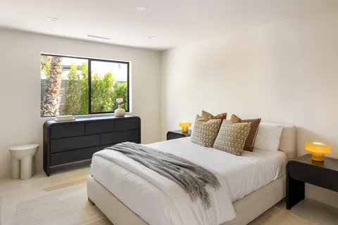 a bedroom with a bed and a large window