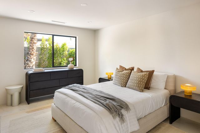 a bedroom with a bed and a large window